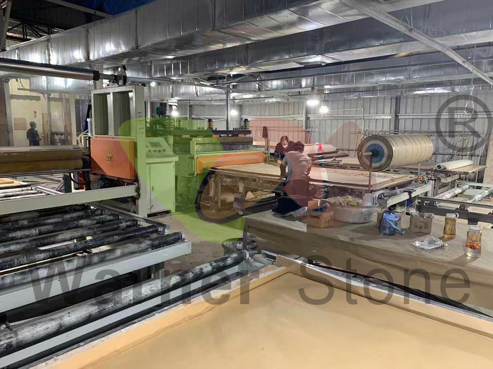 Arbeiter beim Verteilen von Quarzsand und Harzgemisch bei der Herstellung von Platten